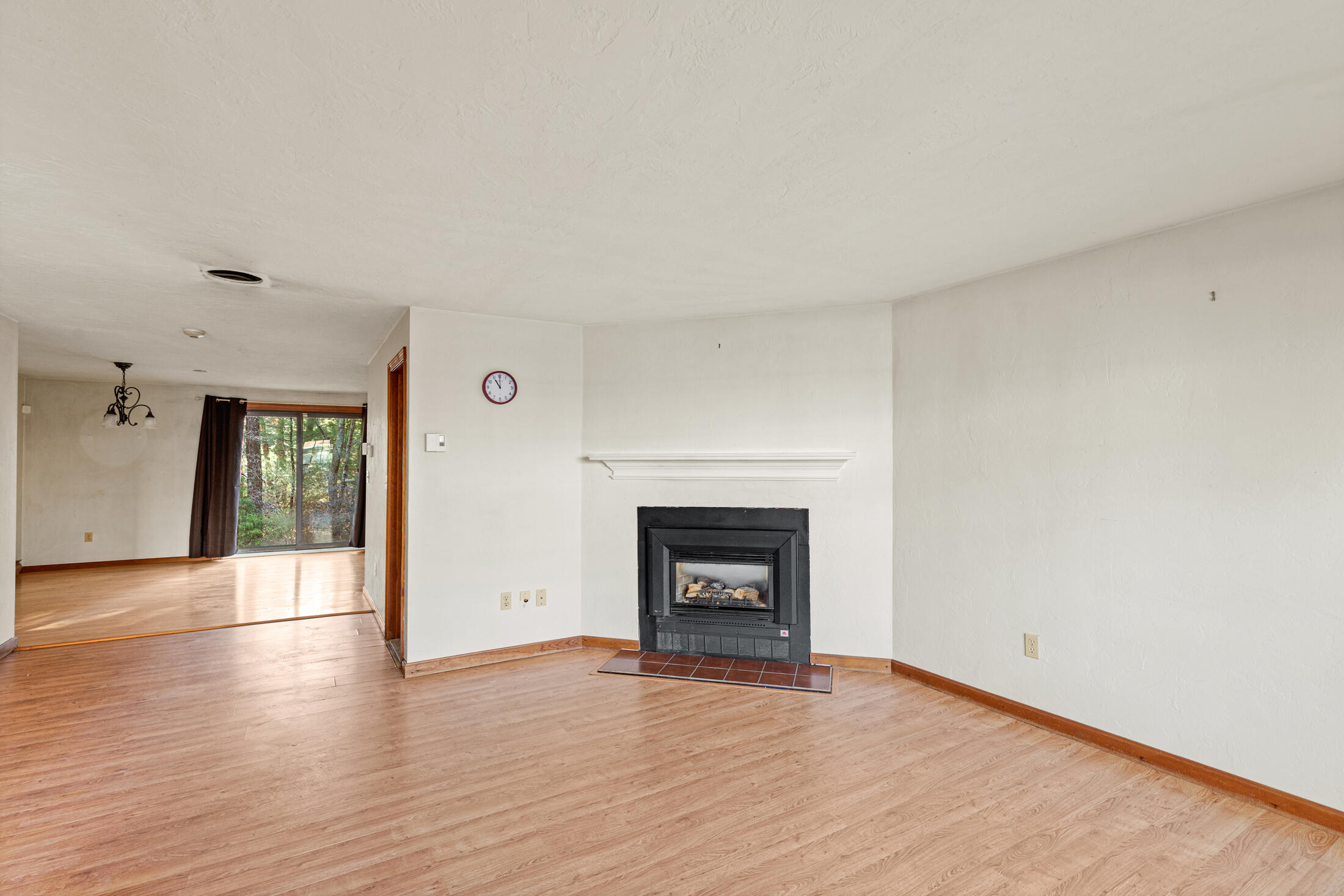 195 Falmouth Road, Unit 19F Mashpee, MA 02649 - Photo 13 of 25 an empty room with wooden floor and a fireplace