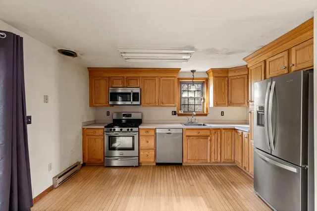 a kitchen with stainless steel appliances granite countertop a refrigerator a stove top oven a sink and dishwasher