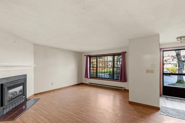 an empty room with wooden floor and fireplace
