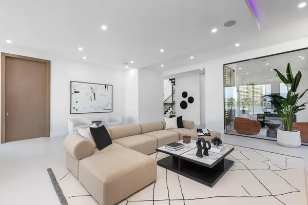 a view of a patio with couches table and chairs under an umbrella