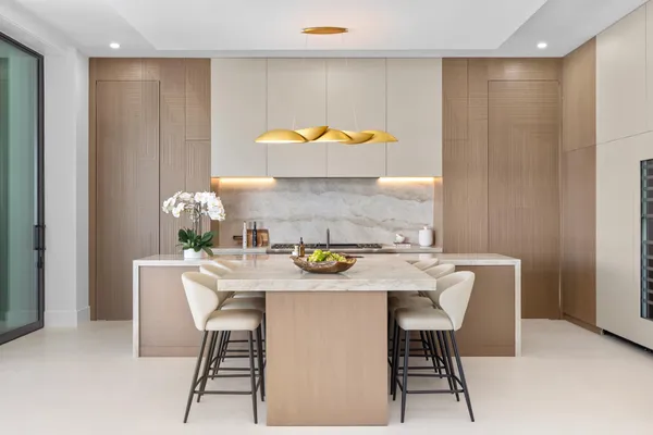 a large white kitchen with a large window and sink