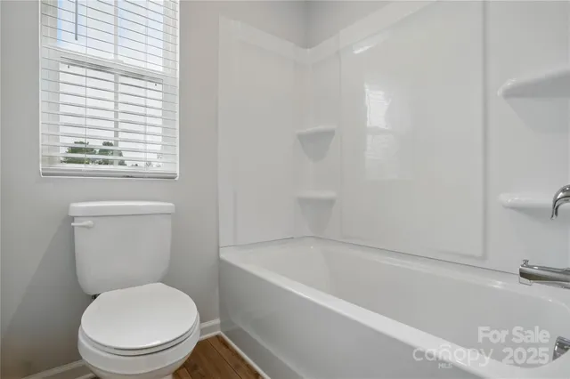 a white toilet sitting next to a bath tub