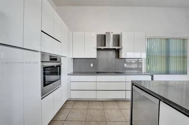 a kitchen with stainless steel appliances granite countertop a sink and a stove