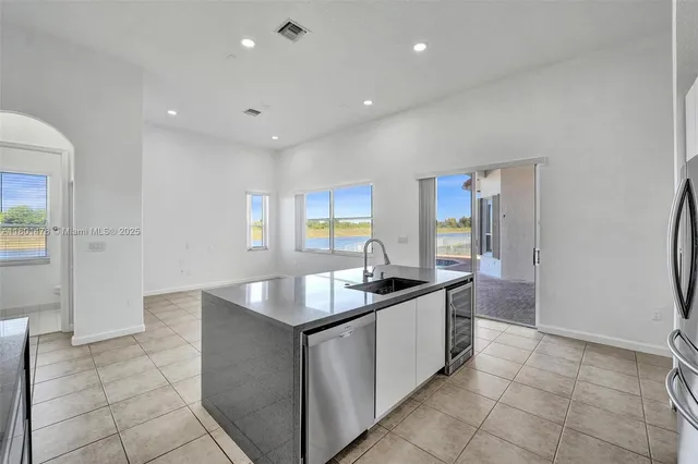a kitchen with stainless steel appliances granite countertop a sink and a refrigerator