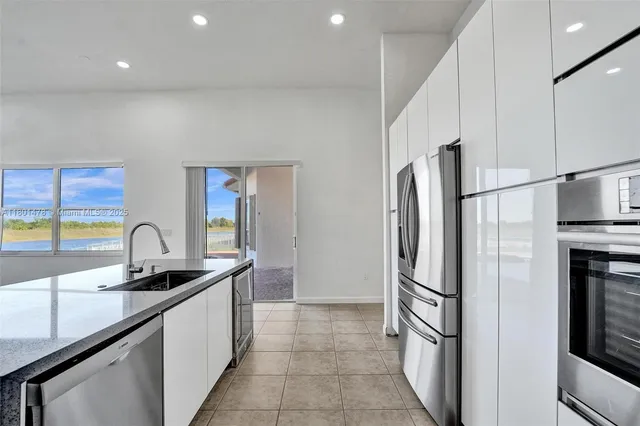 a kitchen with granite countertop a refrigerator and a sink