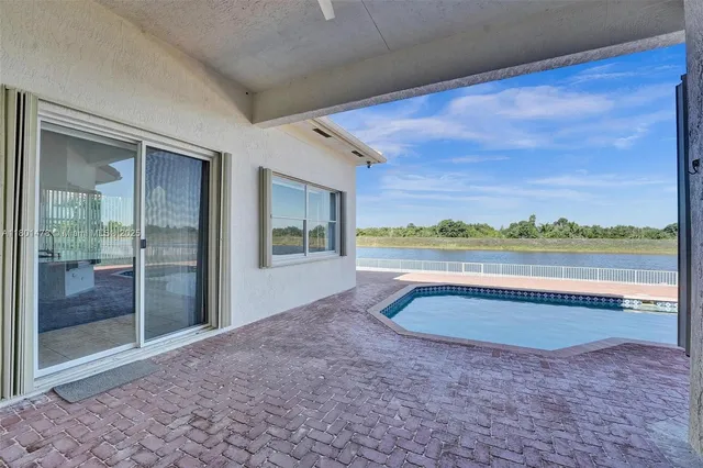 a view of house with swimming pool and yard