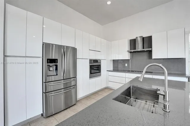 a kitchen with stainless steel appliances a refrigerator sink and microwave
