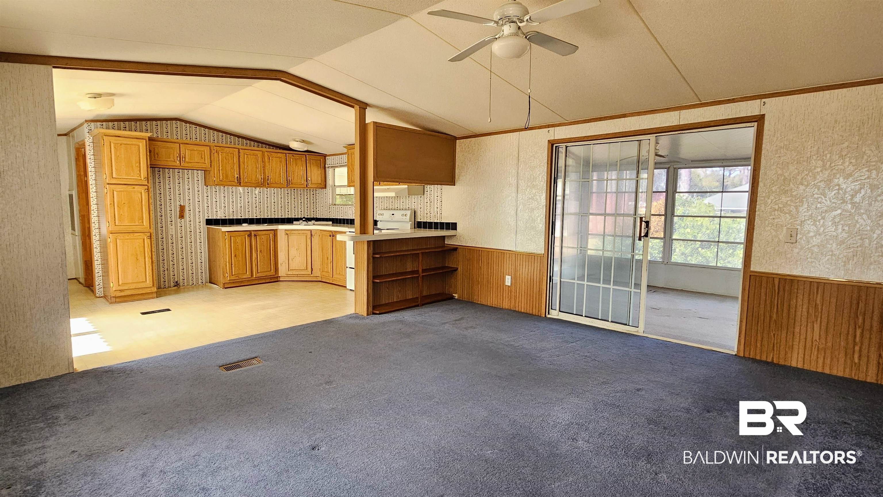 18659 Bull Springs Road Robertsdale, AL 36567 - Photo 2 of 25 Kitchen featuring lofted ceiling, white range with electric cooktop, light colored carpet, kitchen peninsula, and wood walls
