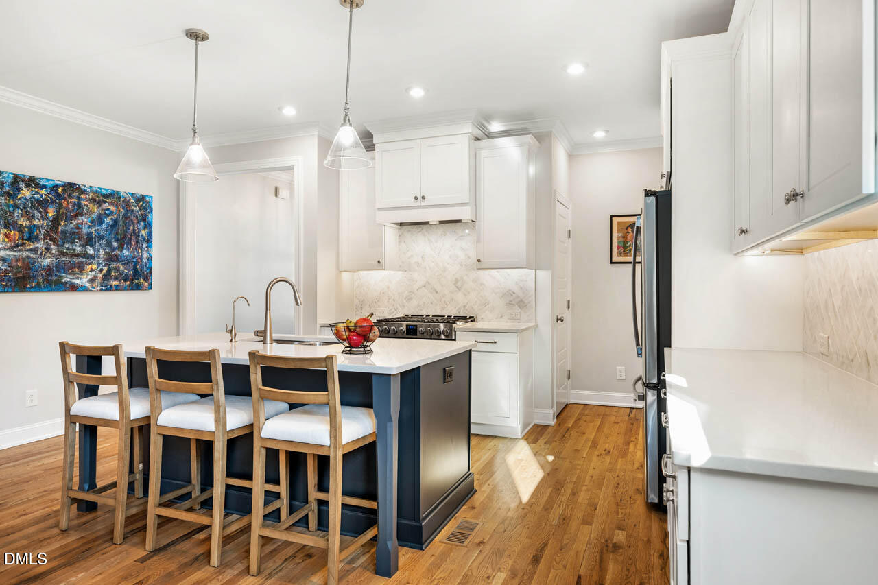56 Post Oak Road Chapel Hill, NC 27516 - Photo 13 of 84 a kitchen with stainless steel appliances kitchen island granite countertop a table chairs sink and cabinets