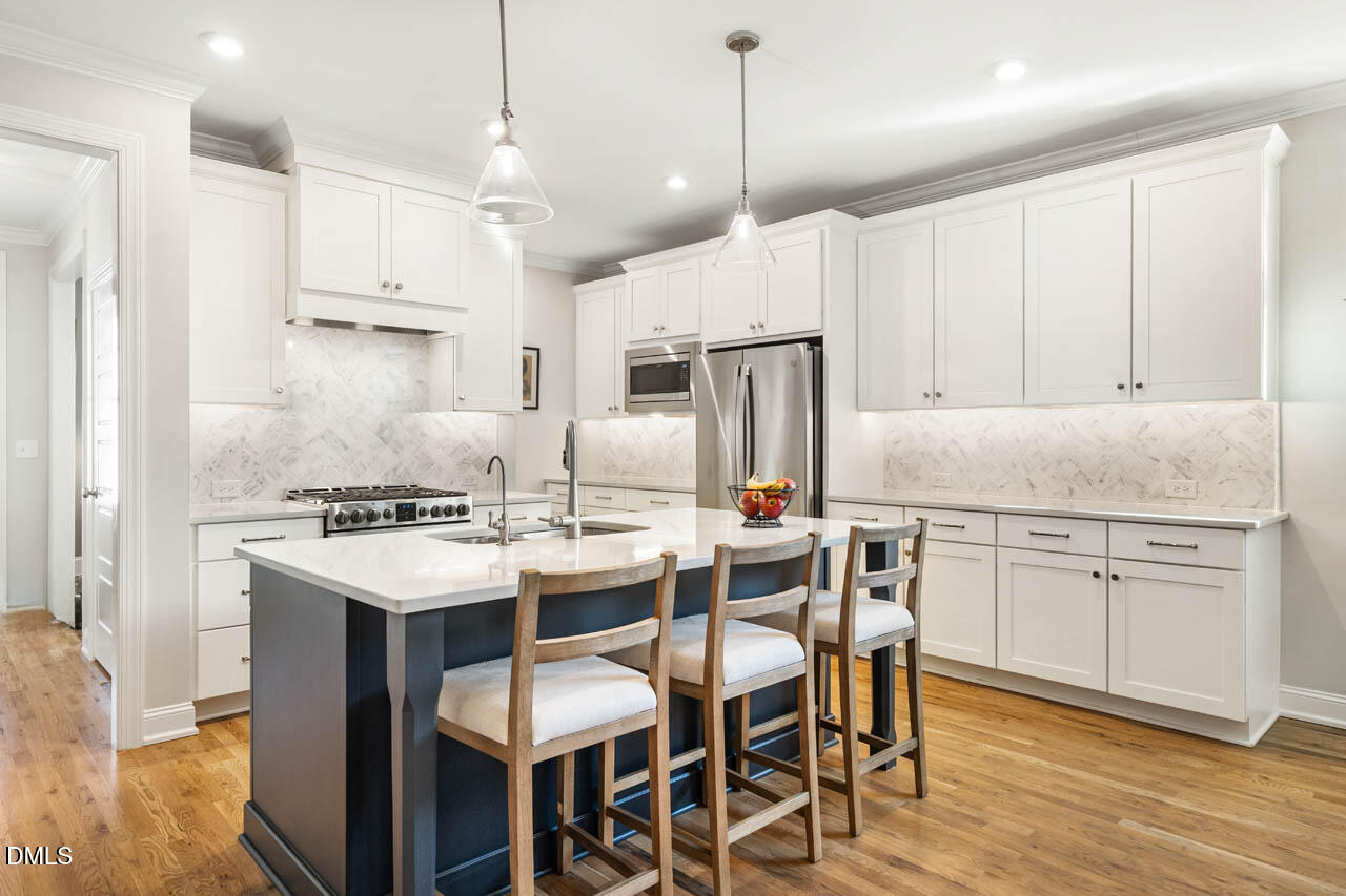 56 Post Oak Road Chapel Hill, NC 27516 - Photo 3 of 84 a kitchen with stainless steel appliances kitchen island granite countertop a table chairs stove and white cabinets