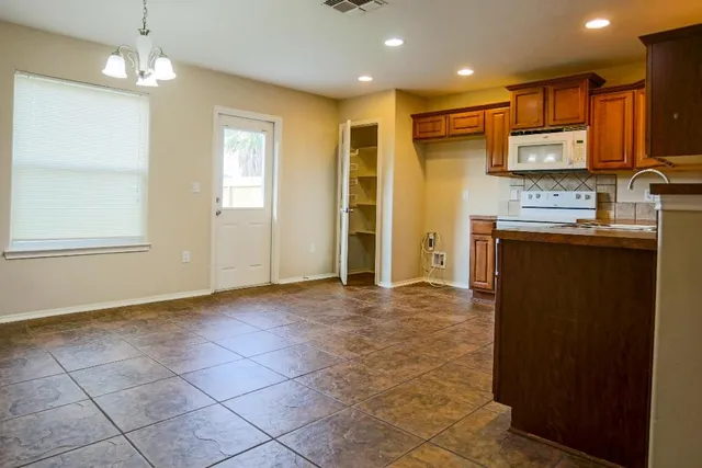 a view of a kitchen with stainless steel appliances granite countertop a refrigerator and a stove top oven