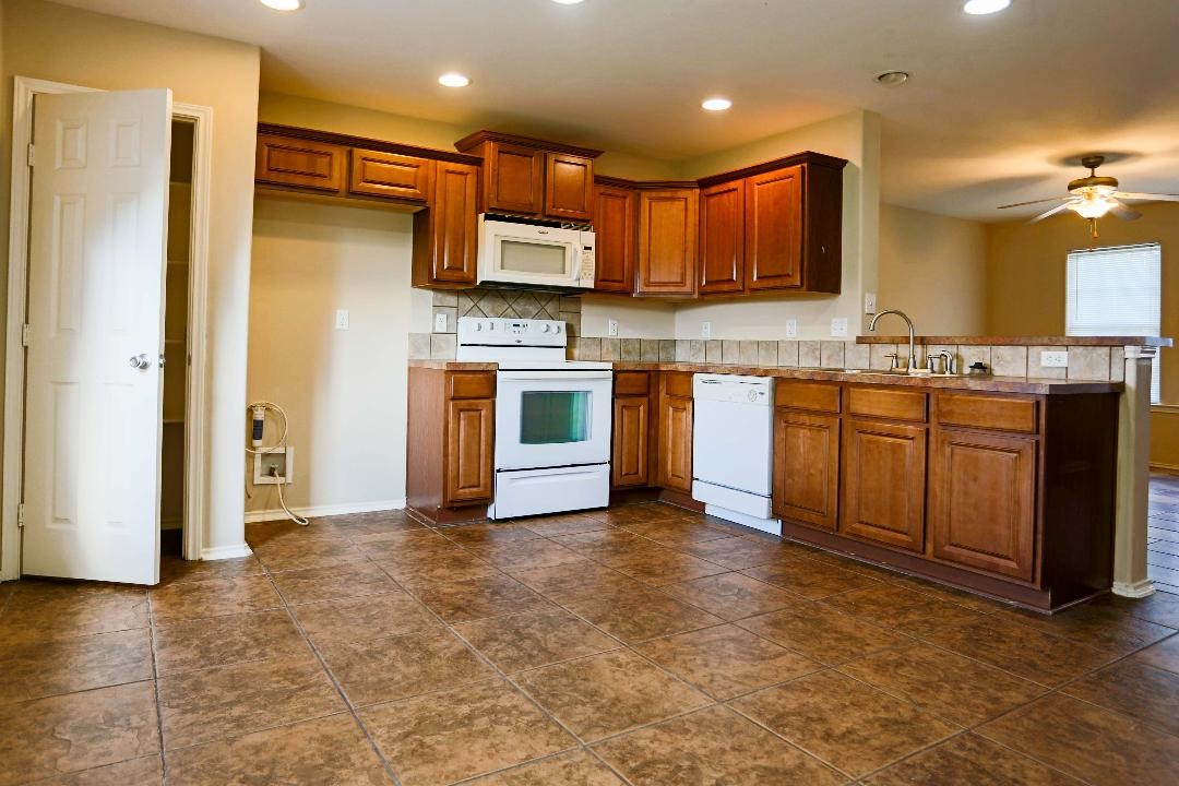 1114 Livermore Street Portland, TX 78374 - Photo 6 of 16 a kitchen with stainless steel appliances granite countertop a refrigerator a stove top oven a sink and dishwasher