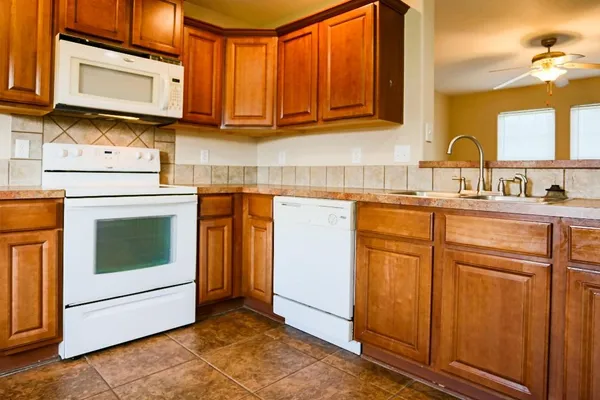 a kitchen with stainless steel appliances granite countertop a sink stove and microwave