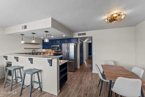 a kitchen with a table chairs refrigerator and microwave