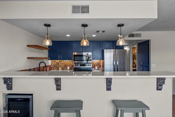 a kitchen with kitchen island stainless steel appliances a dining table and chairs