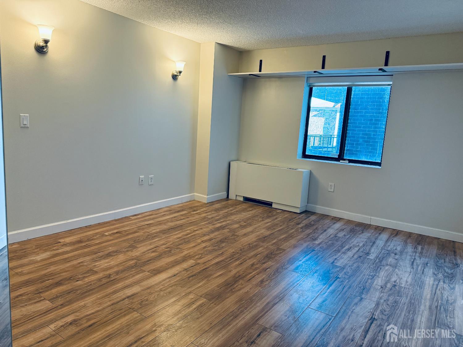 10 North Wood Avenue, Unit 314 Linden, NJ 07036 - Photo 12 of 18 a view of empty room with wooden floor and fan
