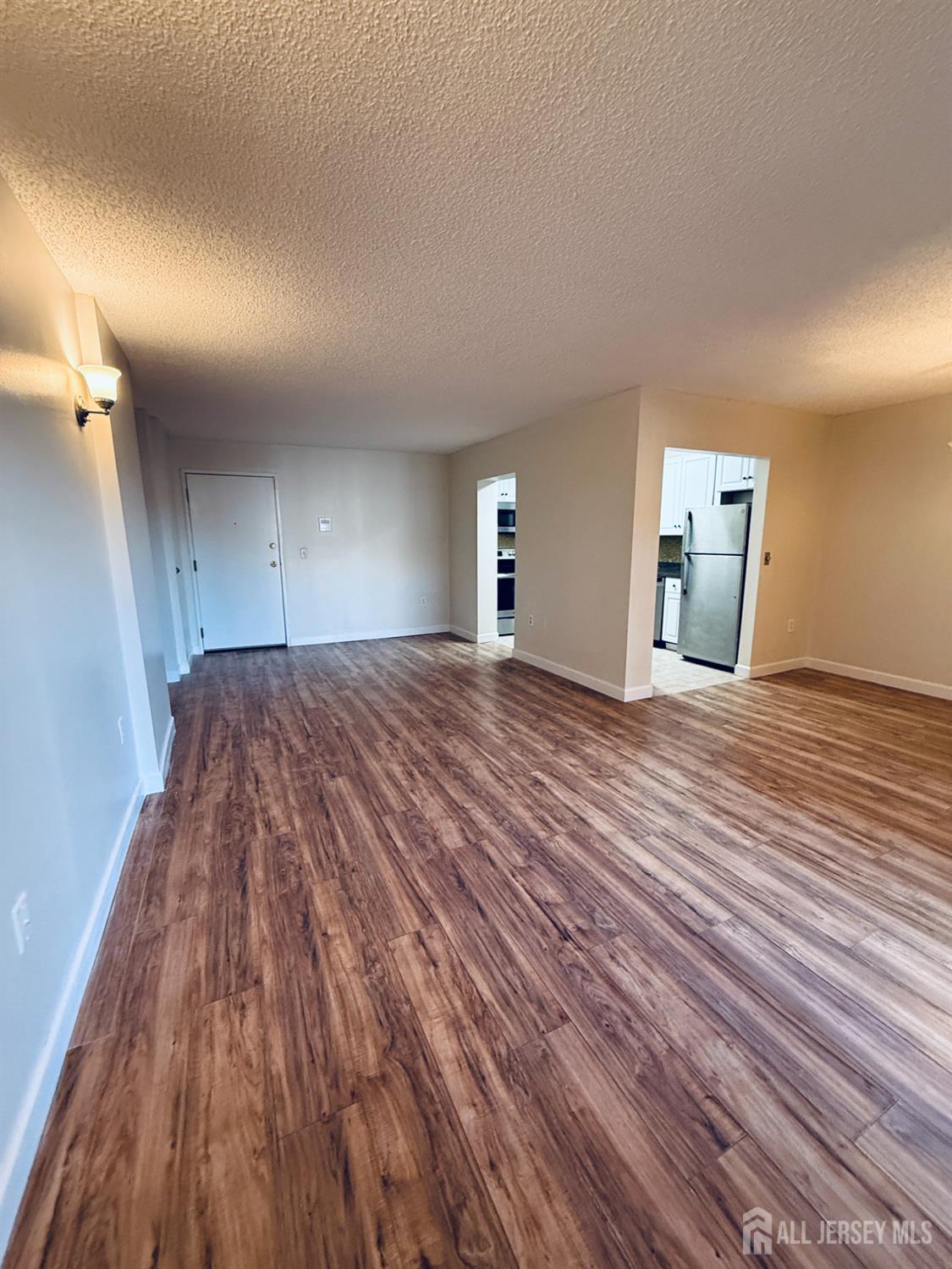 10 North Wood Avenue, Unit 314 Linden, NJ 07036 - Photo 2 of 18 a view of a big room with wooden floor and windows