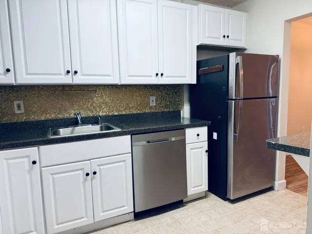 a kitchen with stainless steel appliances white cabinets and a sink