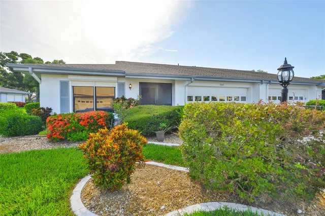 a front view of a house with a yard and potted plants