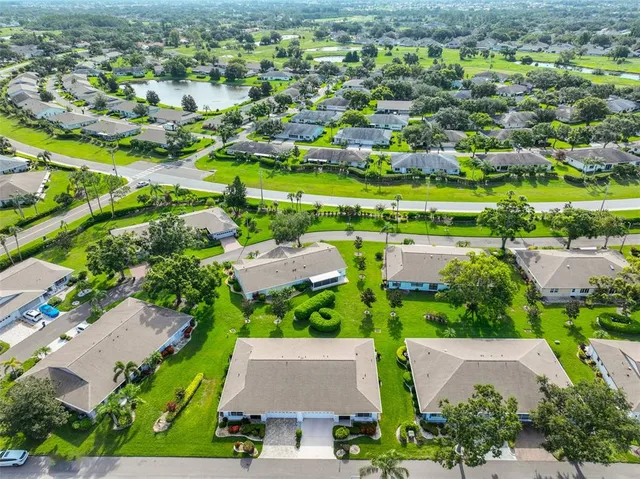 an aerial view of residential houses with outdoor space and trees
