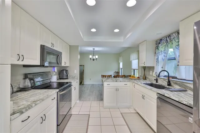 a kitchen with a sink white cabinets and appliances