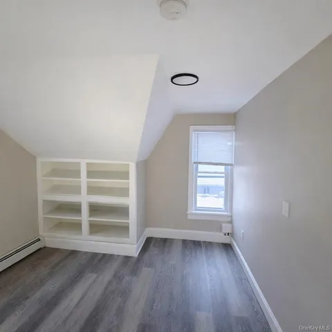 a view of a room with wooden floor and window
