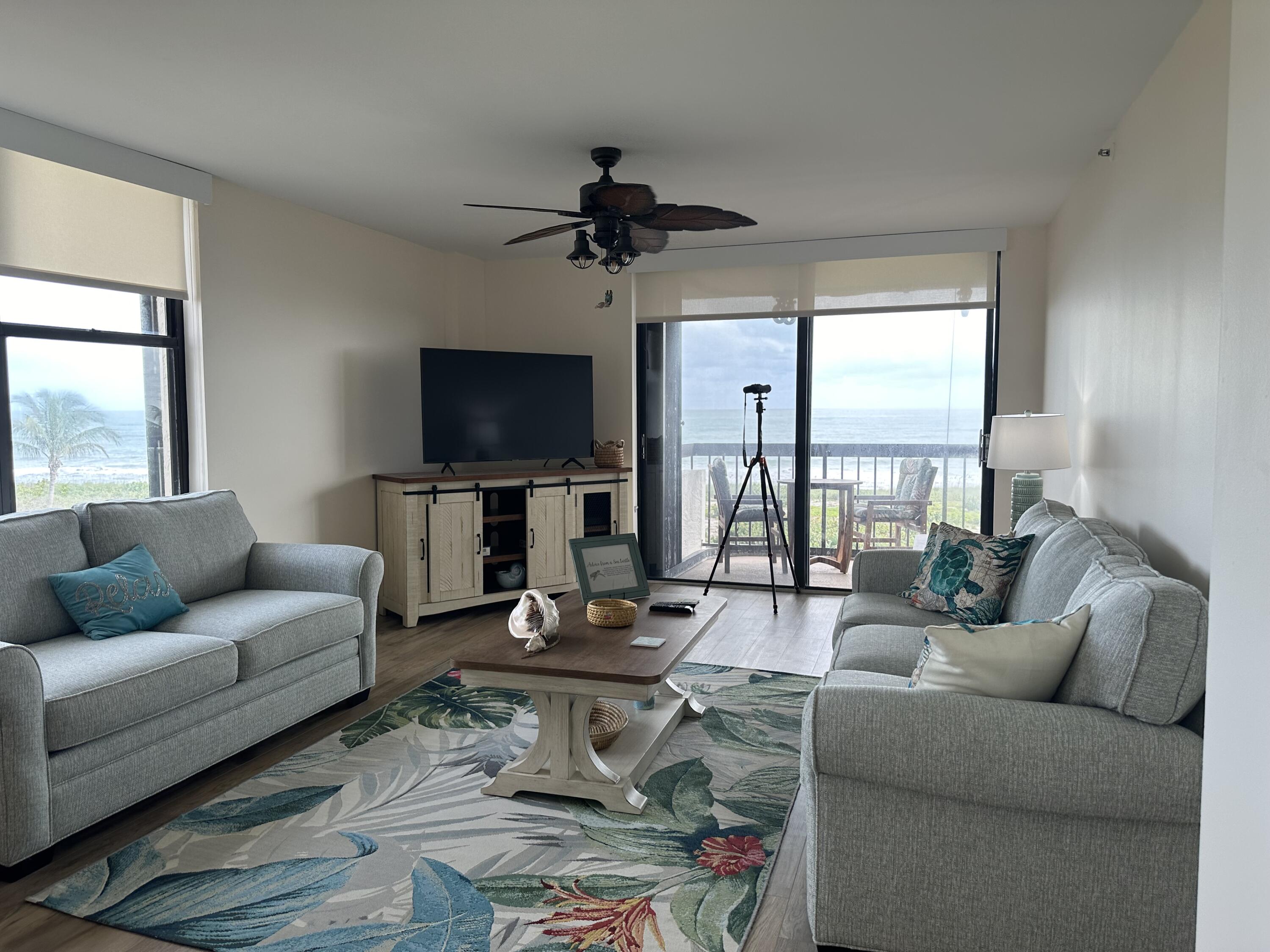 3100 North Hwy A1A, Unit 502 Fort Pierce, FL 34949 - Photo 11 of 44 a living room with furniture a large window and a flat screen tv