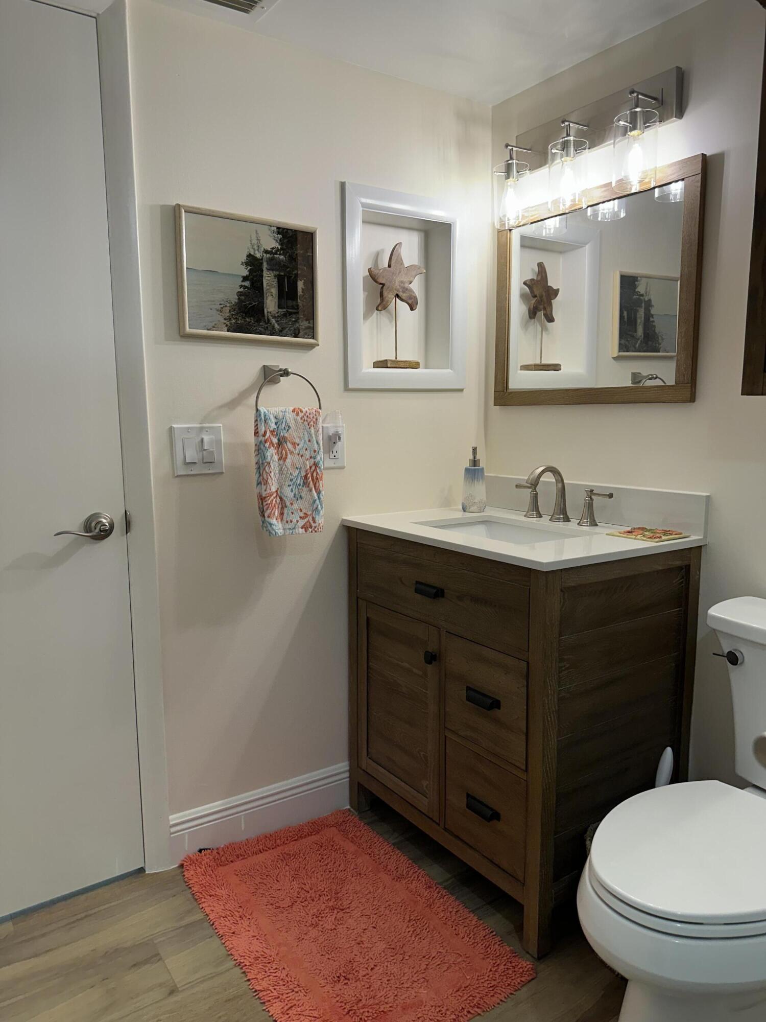 3100 North Hwy A1A, Unit 502 Fort Pierce, FL 34949 - Photo 18 of 44 a bathroom with a toilet sink and mirror