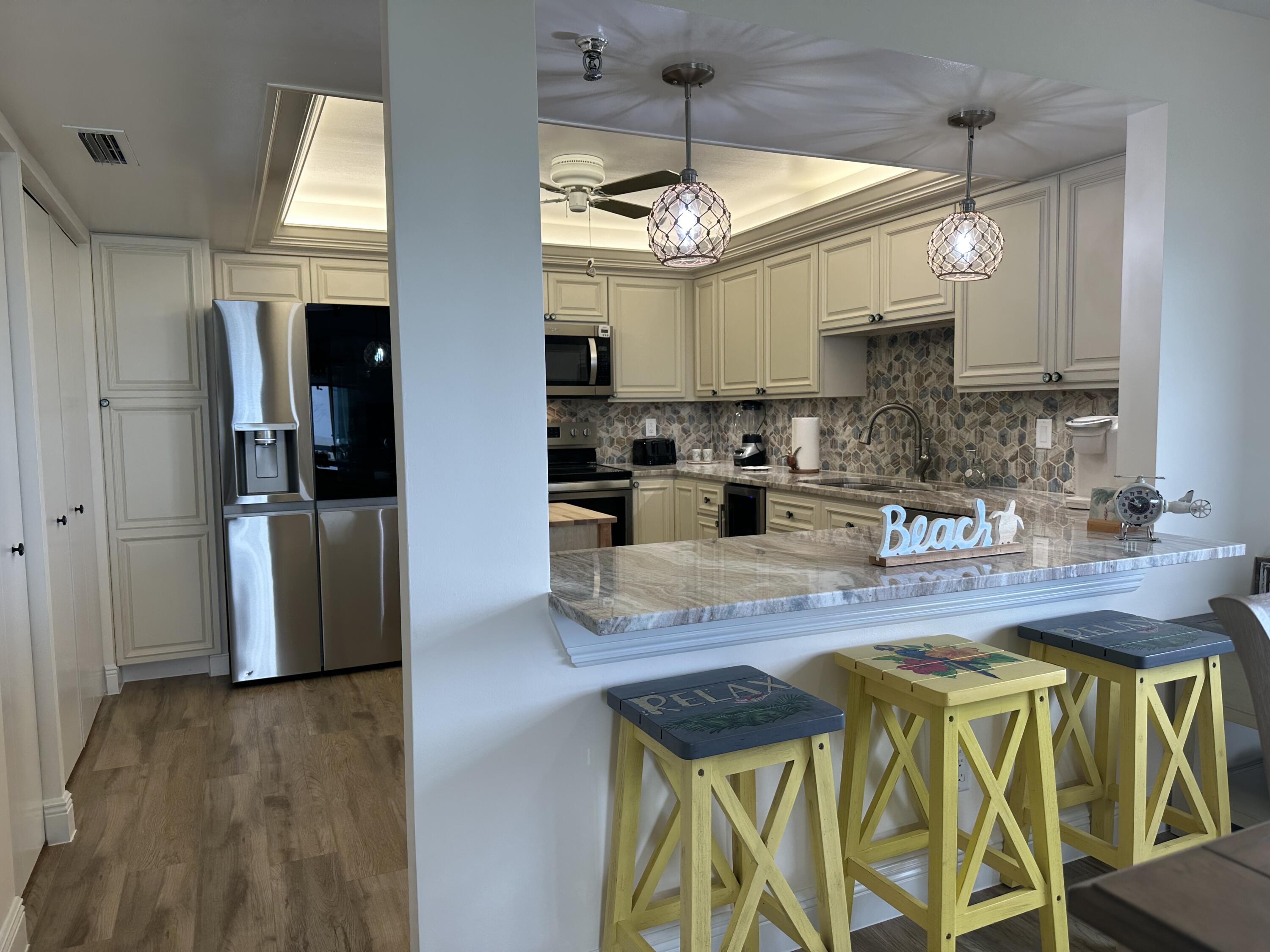 3100 North Hwy A1A, Unit 502 Fort Pierce, FL 34949 - Photo 2 of 44 a kitchen with stainless steel appliances granite countertop wooden floors and sink