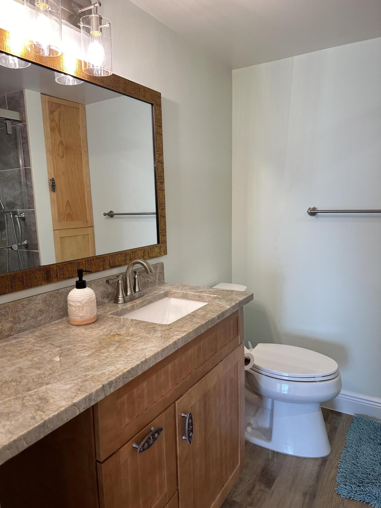 3100 North Hwy A1A, Unit 502 Fort Pierce, FL 34949 - Photo 29 of 44 a bathroom with a granite countertop toilet sink and mirror