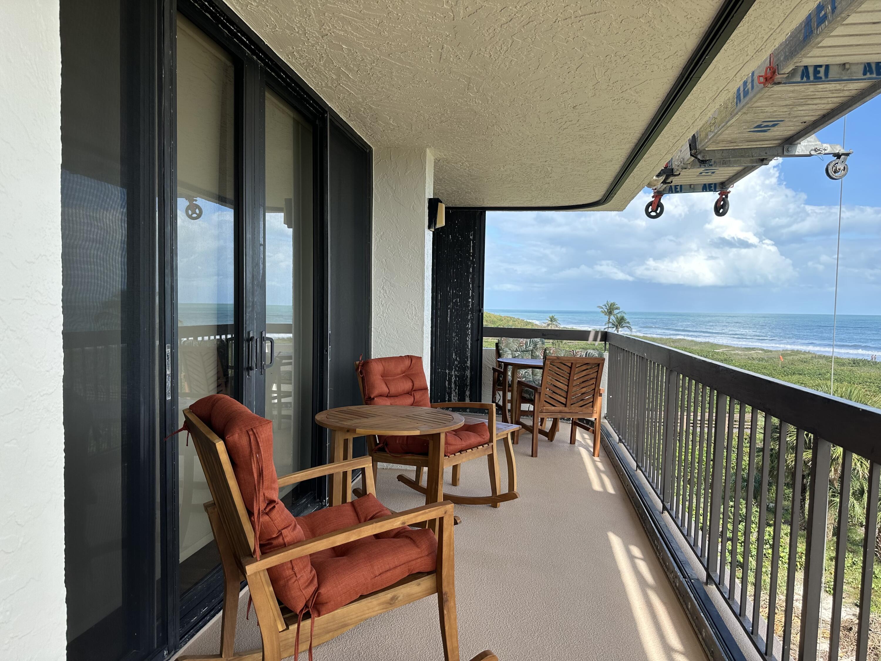 3100 North Hwy A1A, Unit 502 Fort Pierce, FL 34949 - Photo 36 of 44 a balcony with chairs and wooden floor