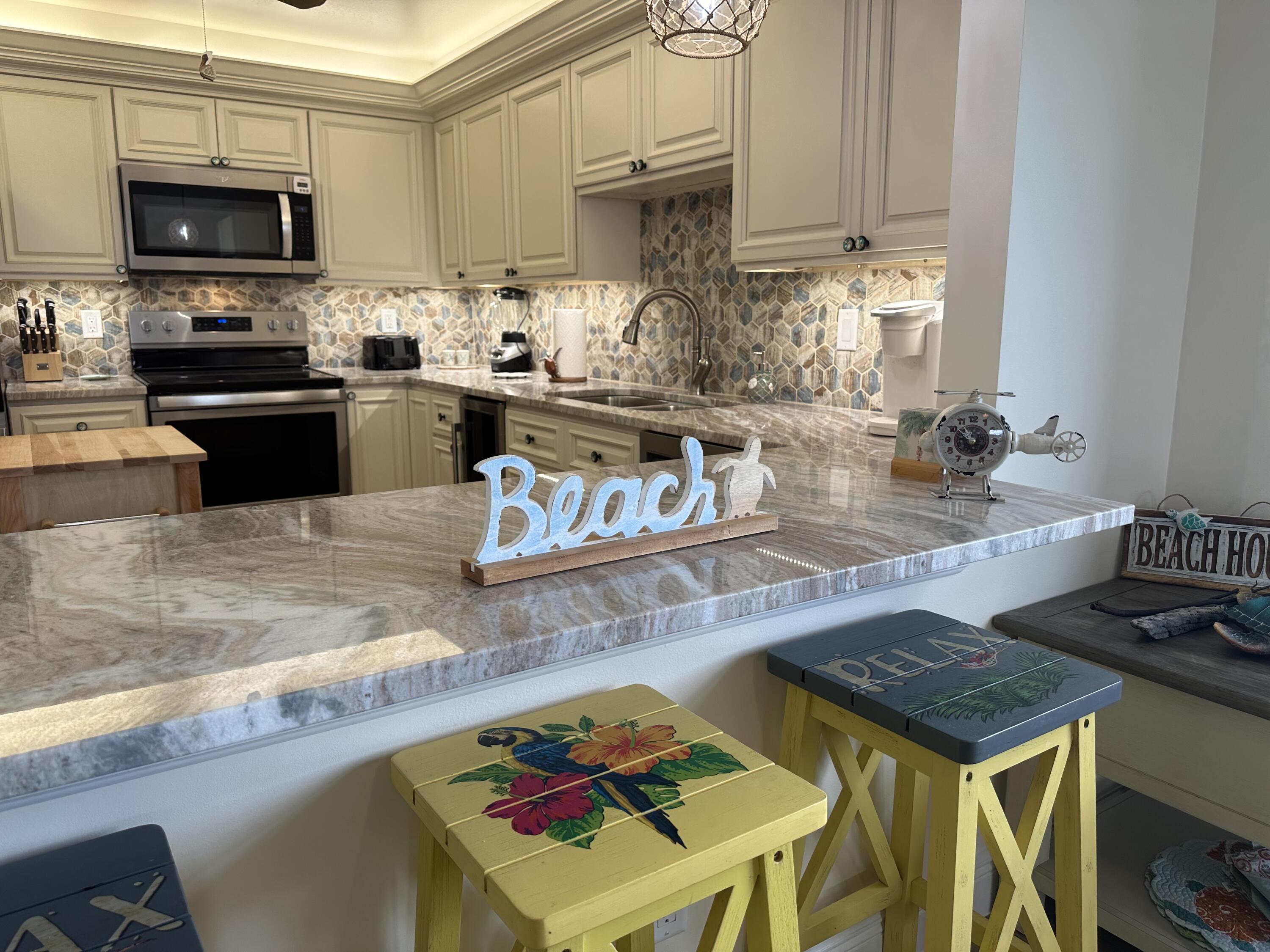 3100 North Hwy A1A, Unit 502 Fort Pierce, FL 34949 - Photo 7 of 44 a kitchen with a stove a sink and a microwave