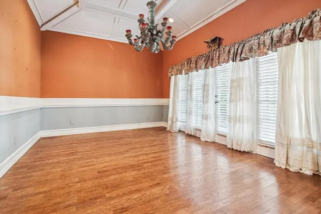 a view of a bedroom with wooden floor and a window