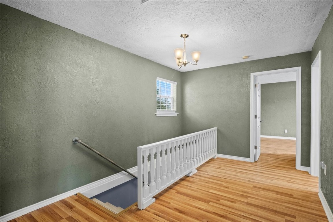 103 Emile Street Brenham, TX 77833 - Photo 11 of 22 a view of a hallway with wooden floor and stairs