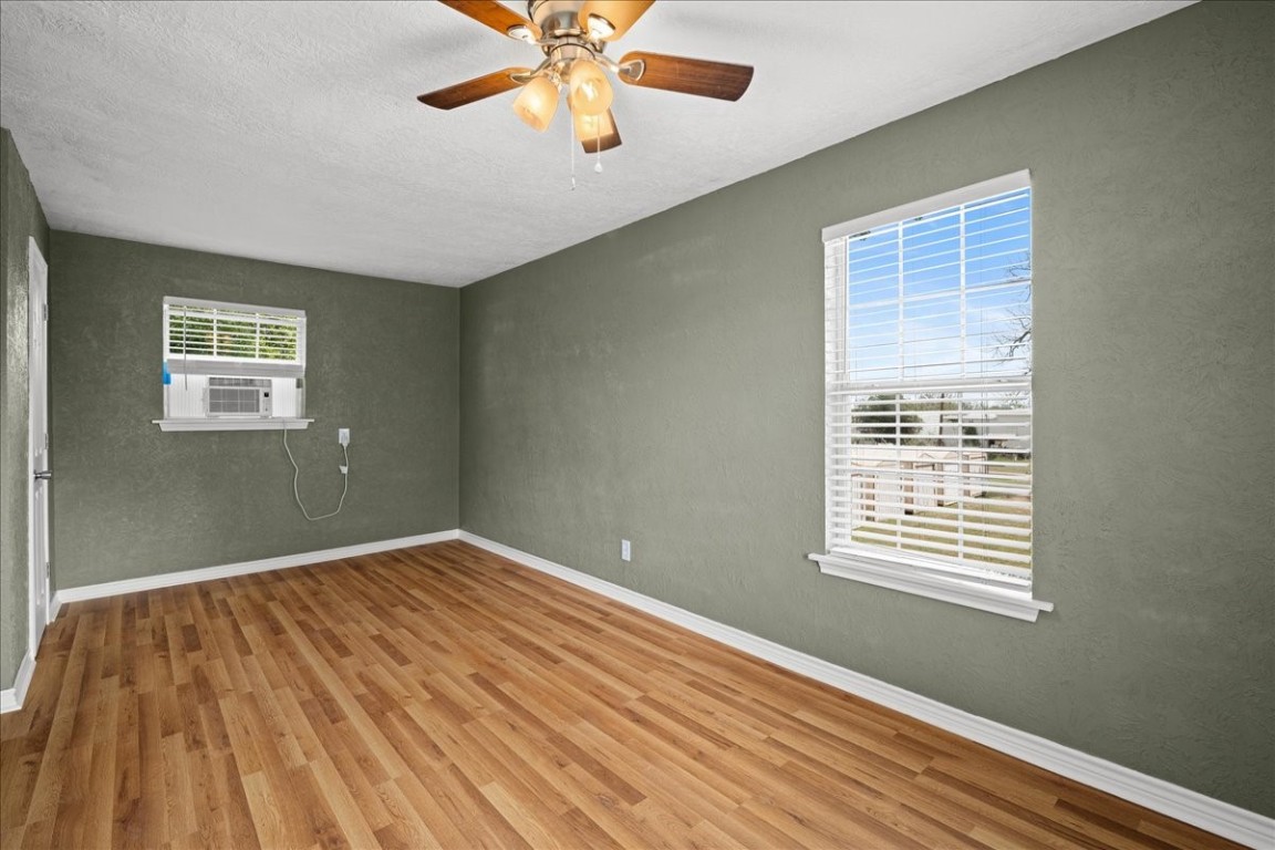 103 Emile Street Brenham, TX 77833 - Photo 17 of 22 a view of an empty room with a window and wooden floor