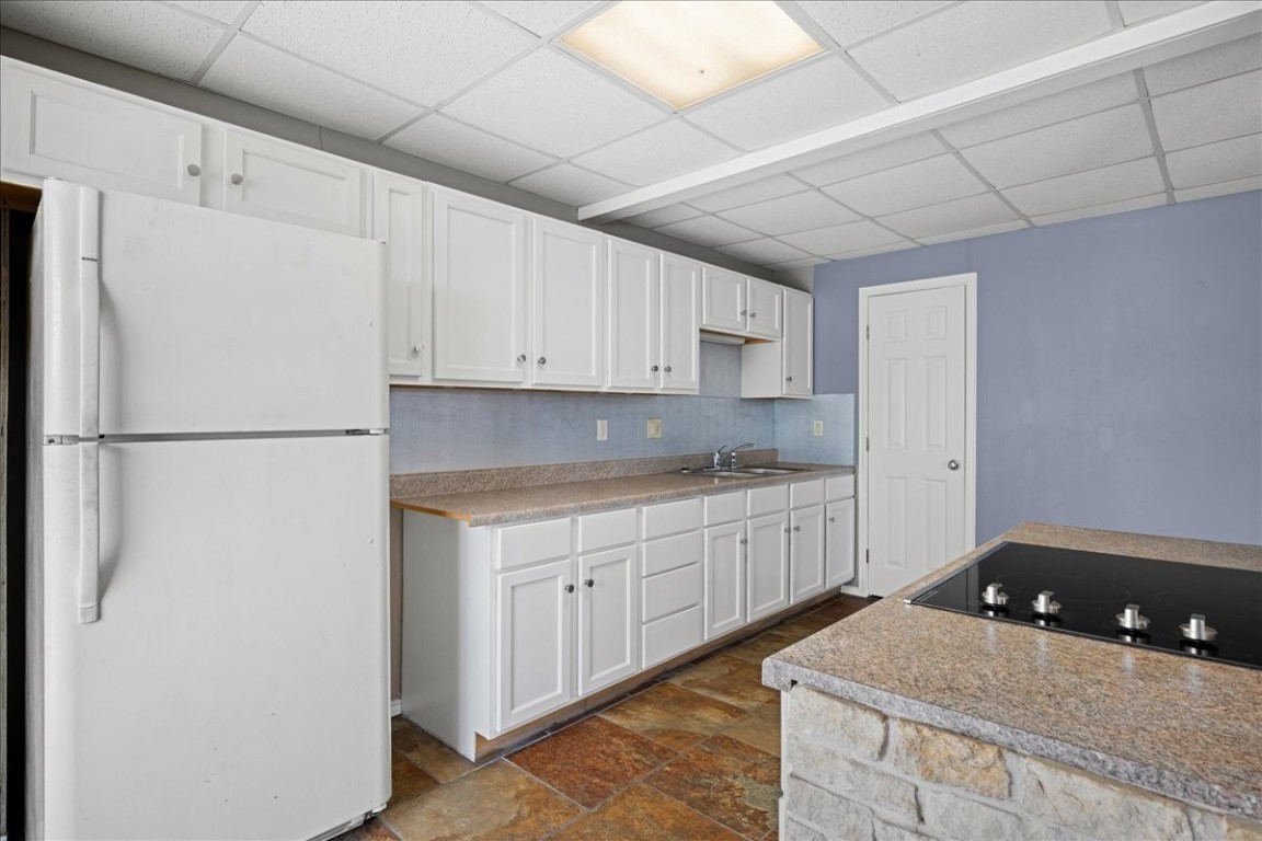 103 Emile Street Brenham, TX 77833 - Photo 9 of 22 a kitchen with stainless steel appliances granite countertop a refrigerator sink and white cabinets