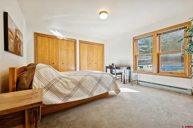 a bed sitting in a spacious bedroom next to a window