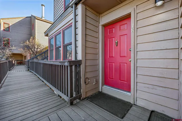 a view of a house with a red door and wooden floor