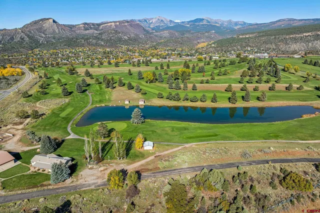 an aerial view of a city with lots of residential buildings and mountain view in back