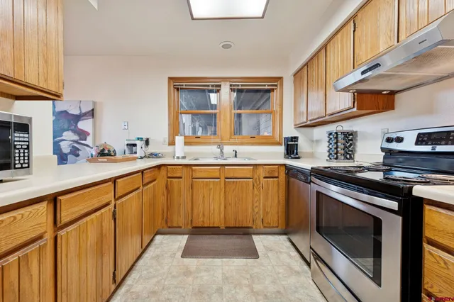 a kitchen with stainless steel appliances granite countertop a stove and a sink