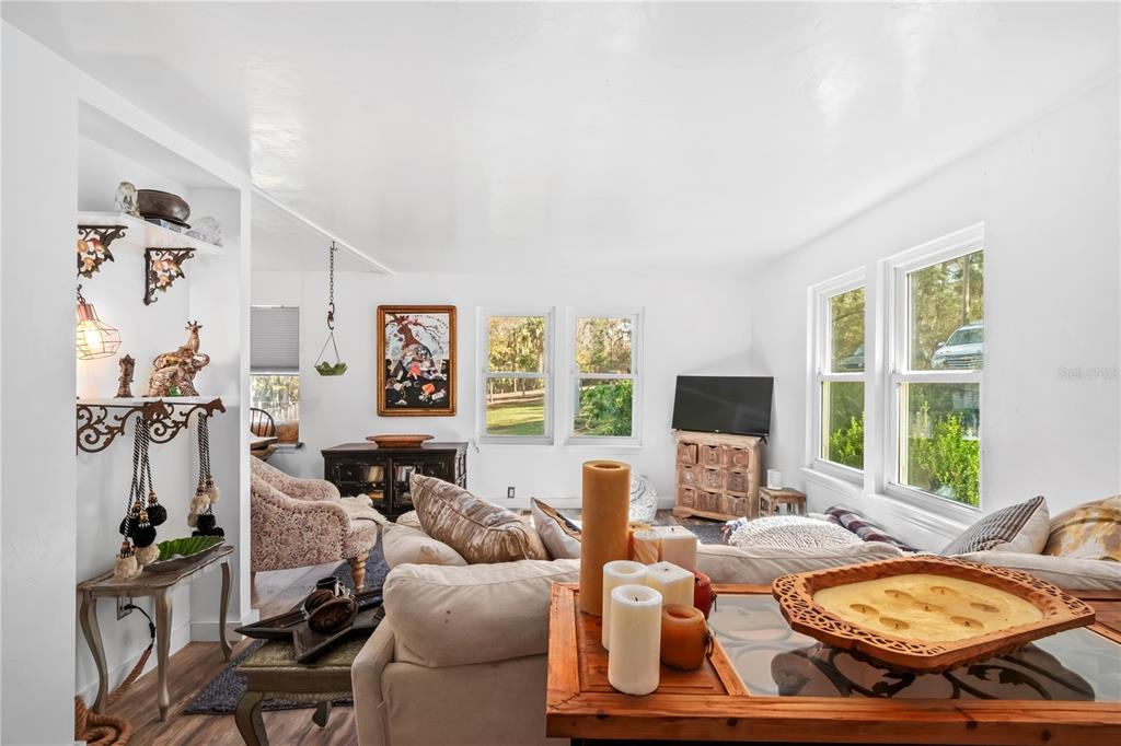 22924 Northwest 91st Court Road Micanopy, FL 32667 - Photo 11 of 95 a living room with furniture flat screen tv and a large window