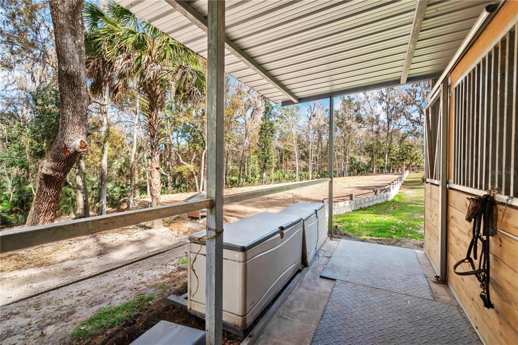 22924 Northwest 91st Court Road Micanopy, FL 32667 - Photo 71 of 95 a porch with a bench next to a yard