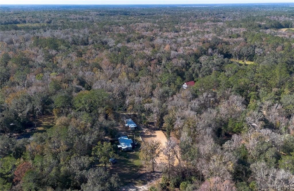 22924 Northwest 91st Court Road Micanopy, FL 32667 - Photo 77 of 95 an aerial view of house with yard and mountain view in back