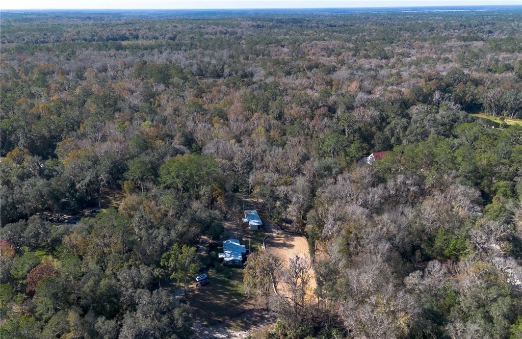 22924 Northwest 91st Court Road Micanopy, FL 32667 - Photo 78 of 95 an aerial view of house with yard and mountain view