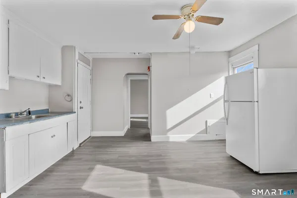 a kitchen with granite countertop a refrigerator a sink and dishwasher
