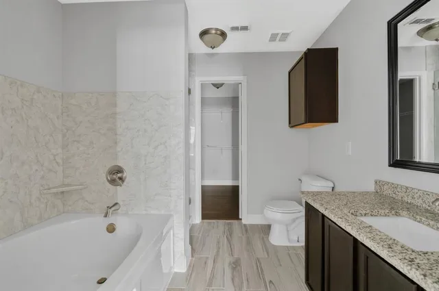 a bathroom with a granite countertop sink toilet and shower