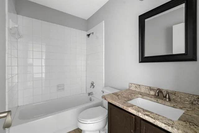 a bathroom with a granite countertop toilet a sink and a bathtub