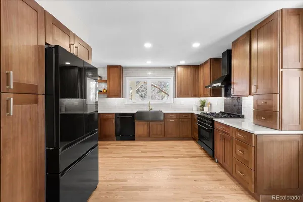 a kitchen with stainless steel appliances granite countertop a refrigerator and a stove