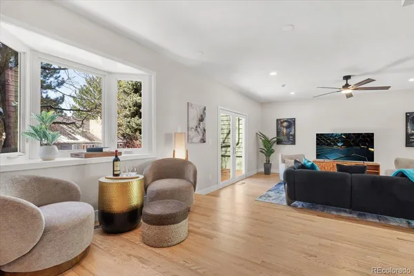 a living room with furniture a flat screen tv and a large window