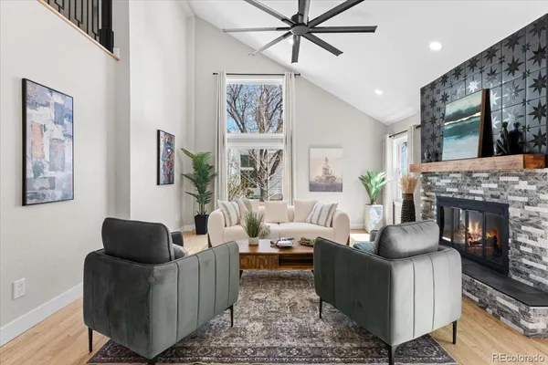 a living room with furniture a fireplace and a large mirror